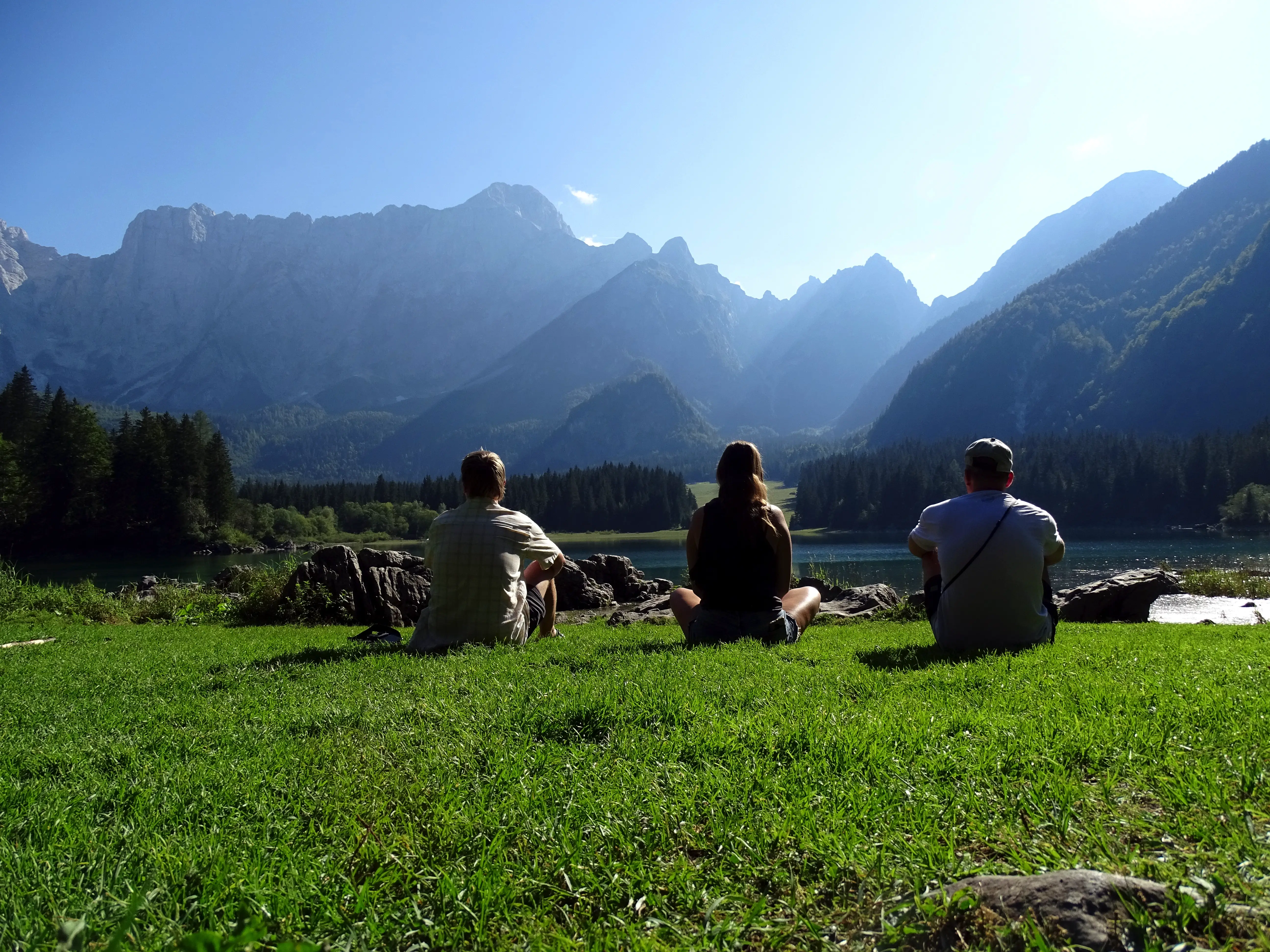 Freunde genießen die Aussicht auf einer Wiese in den Bergen