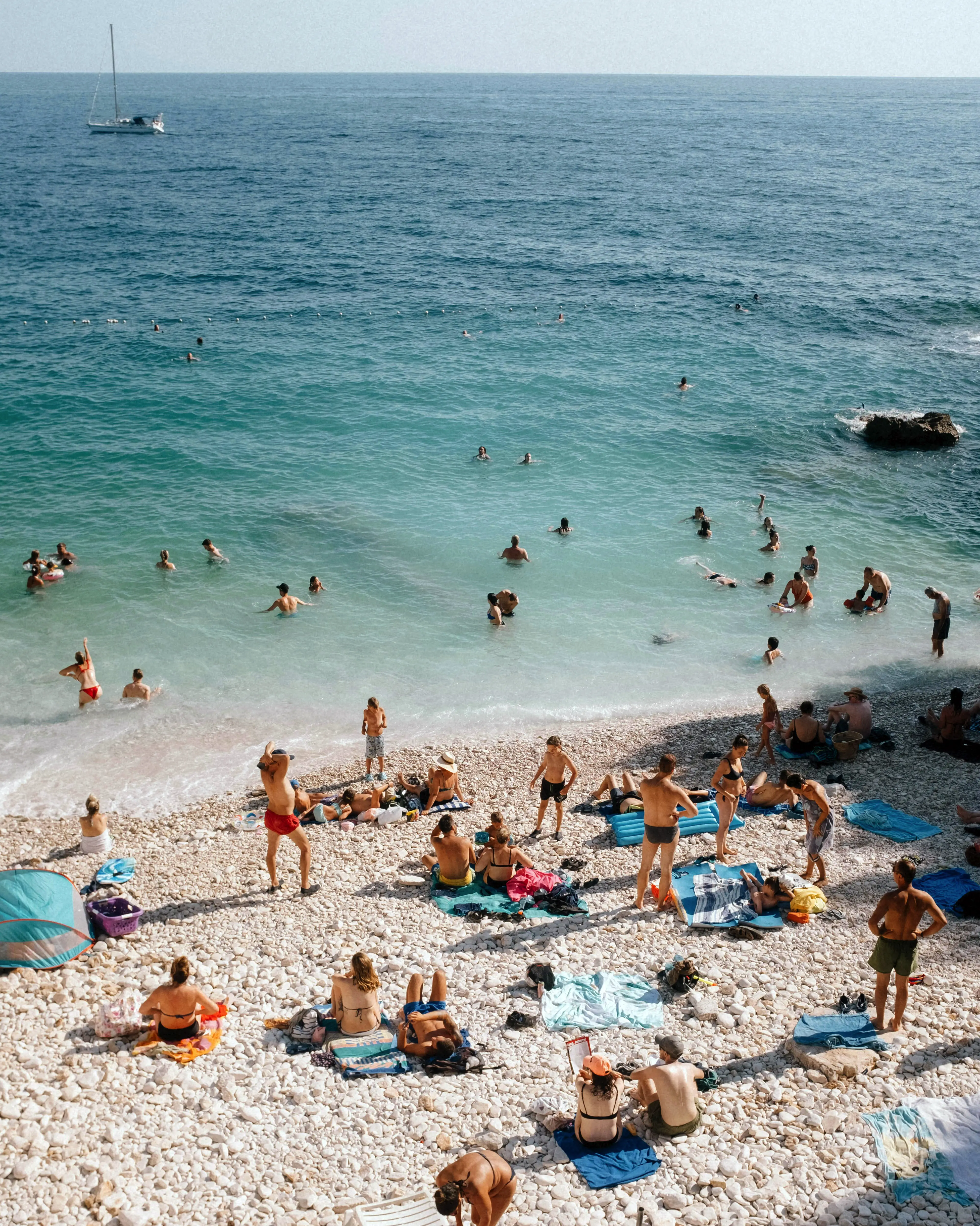 Sommertag an einem Strand mit badenden Menschen